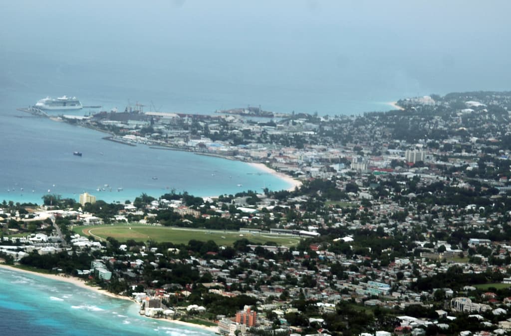 Barbados west coast beach with calm sea and palms below elegant hillside villas