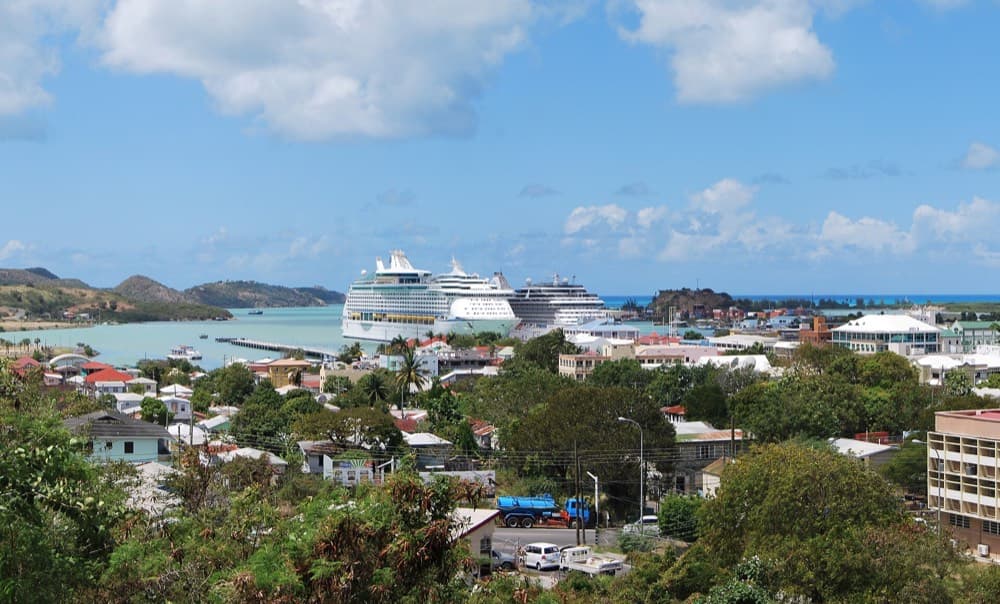 Antigua's English Harbour with yachts anchored below green hills and historic forts