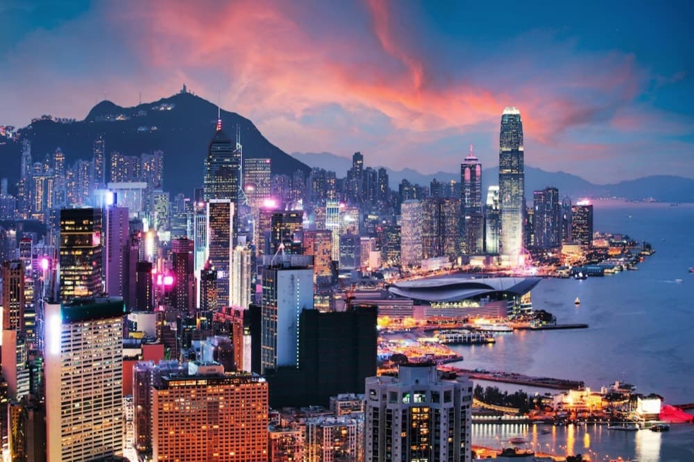 Victoria Harbour framed by dense skyscrapers and the Peak at twilight