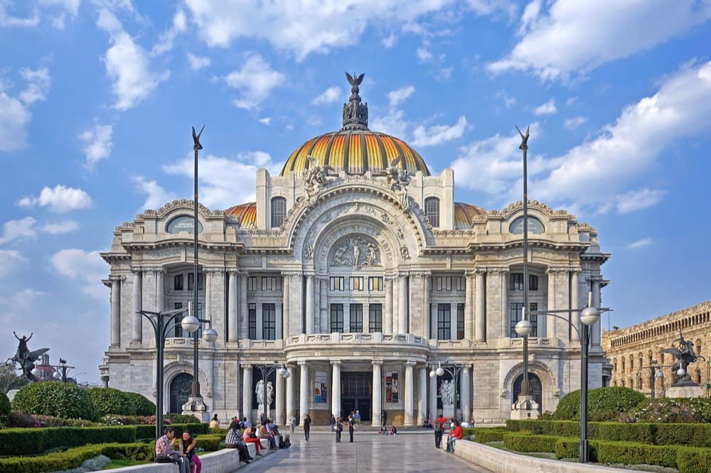 Mexico City skyline sprawling toward volcanic peaks under high-altitude light