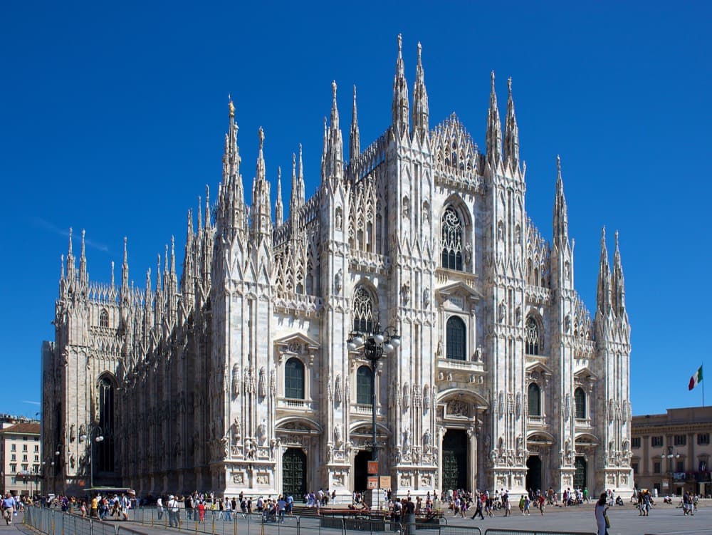The Gothic spires of the Duomo di Milano rising above the piazza at dawn