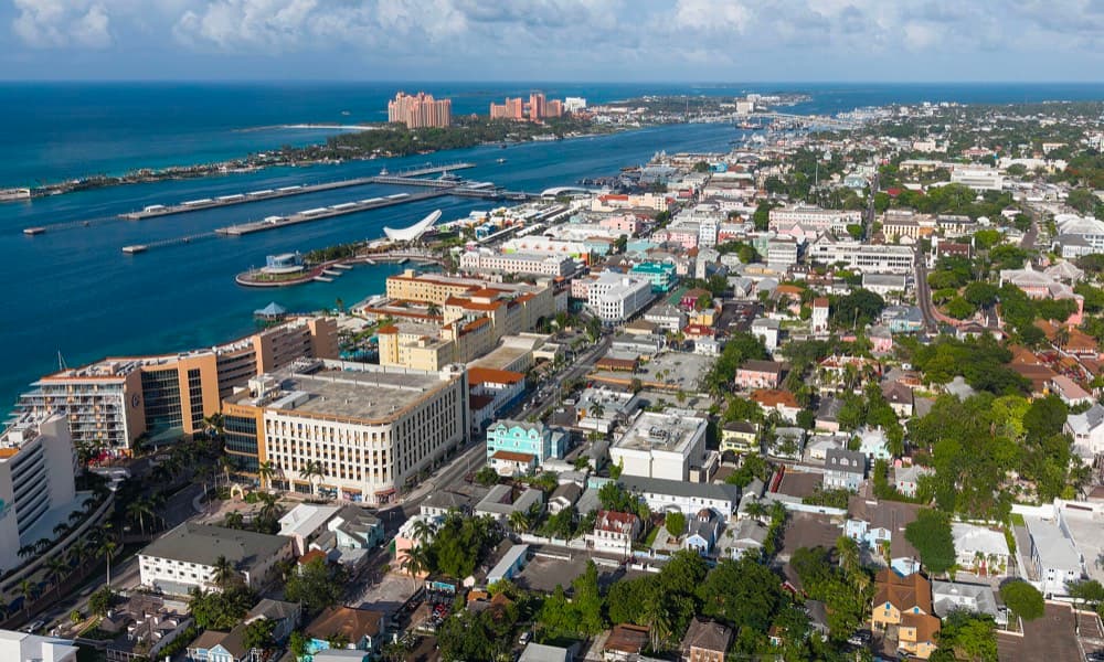 Turquoise water and pastel colonial buildings along Nassau harbor with cruise ships