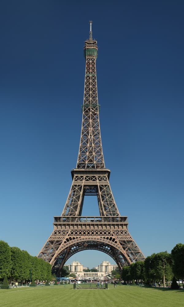 The Eiffel Tower rising above Haussmann rooftops along the Seine at golden hour
