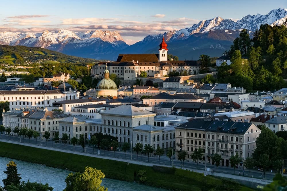Salzburg old town and Hohensalzburg Fortress framed by snow-capped Alpine peaks