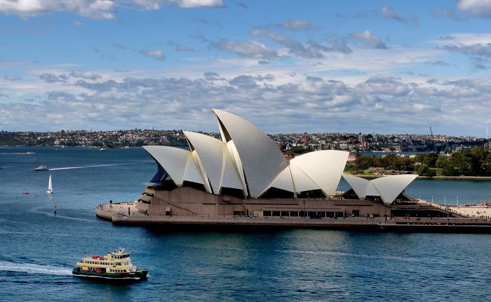 Sydney Opera House and Harbour Bridge framing the blue harbor from above