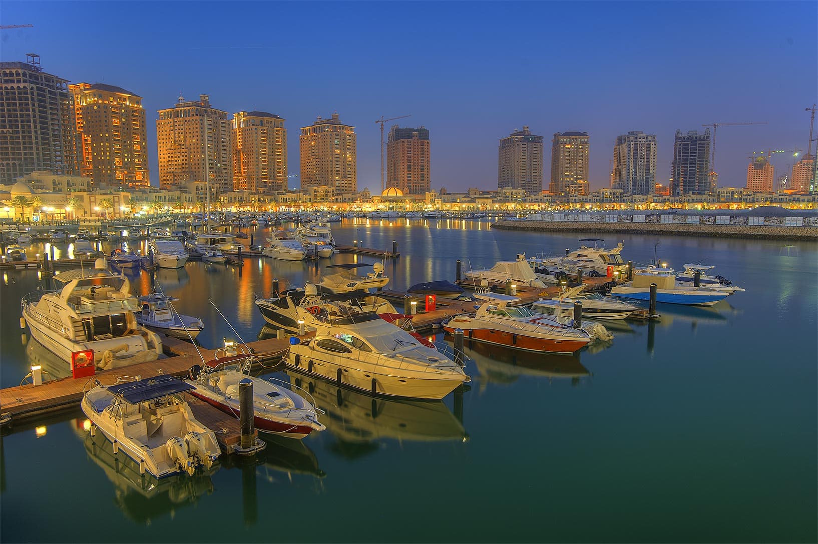 Doha's West Bay skyscrapers reflected across the Corniche waterfront at night