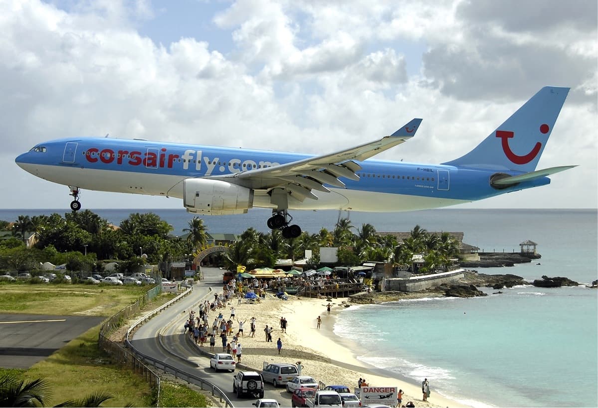 Jet descending low over Maho Beach toward the runway on turquoise Sint Maarten